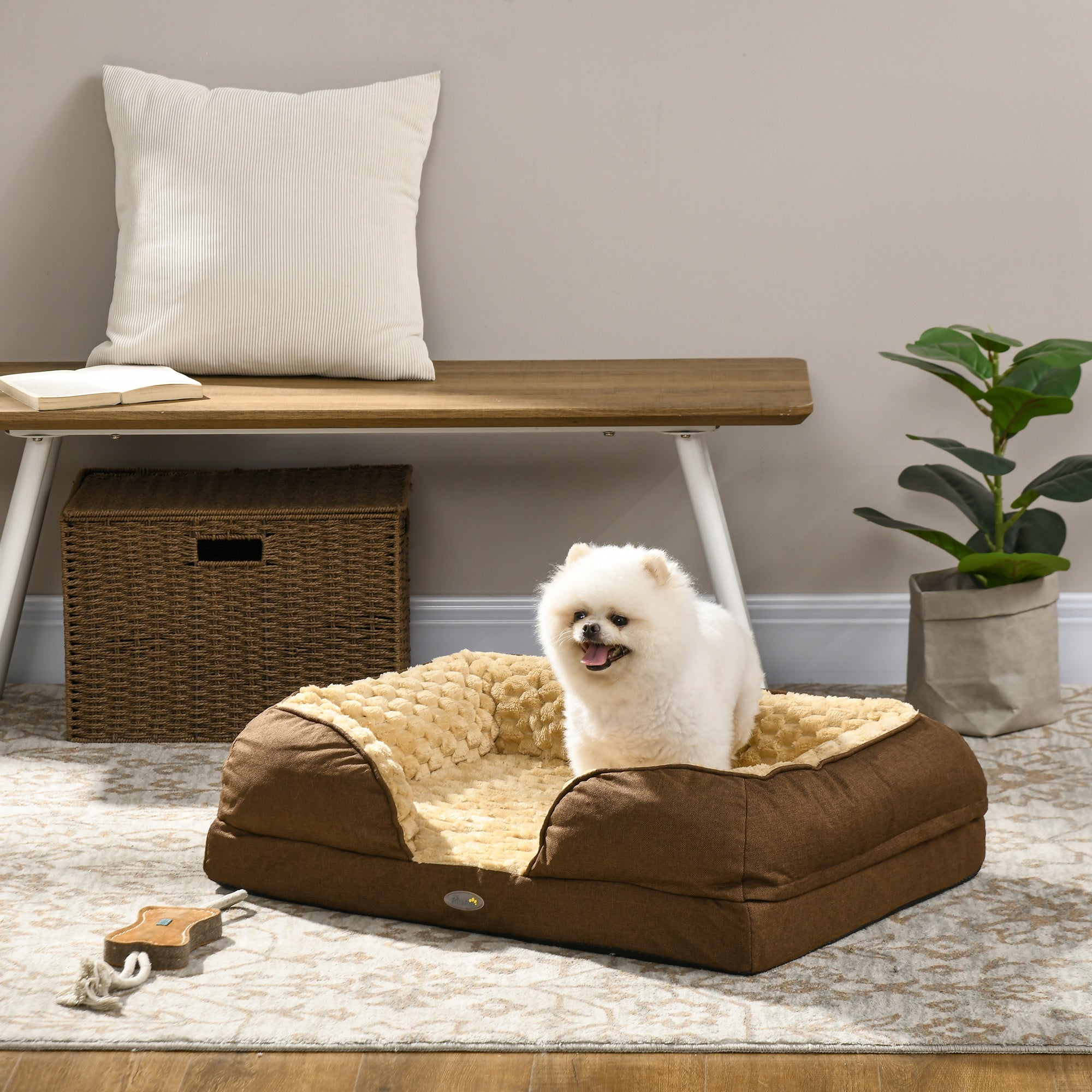 Dog sitting on a brown pet bed in a cozy living room.