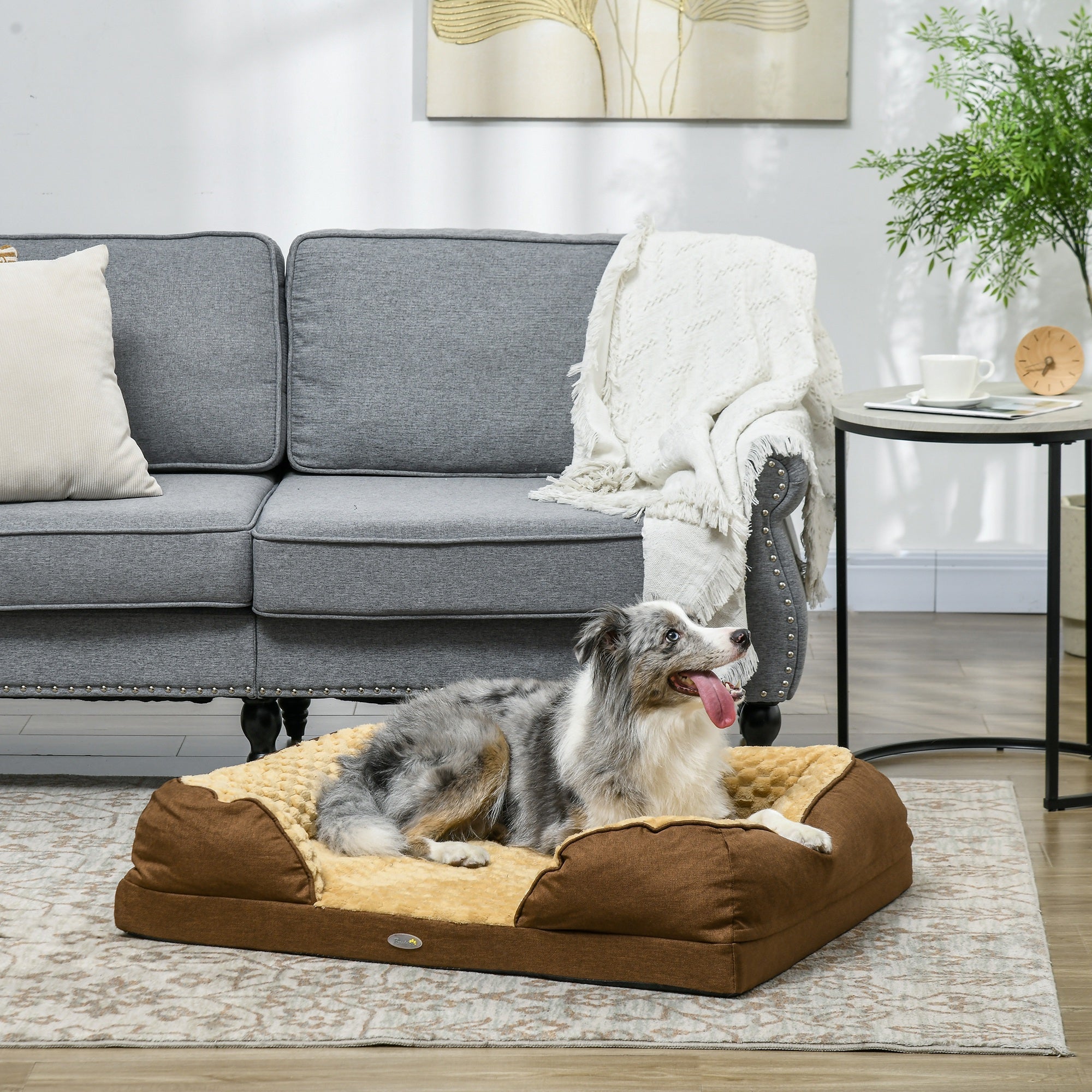 Two dogs on a large brown pet bed in a living room setting.