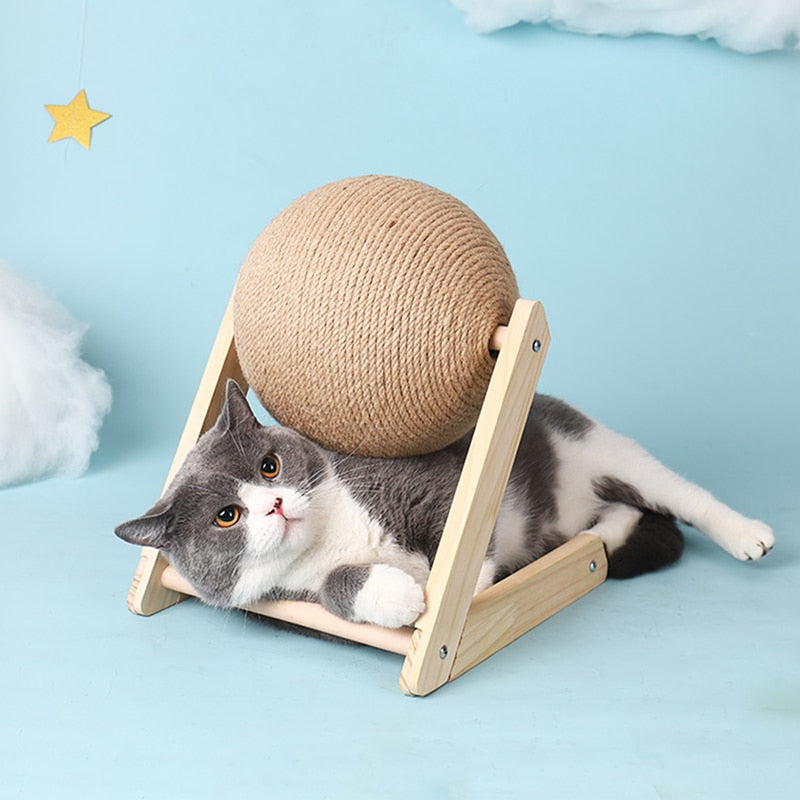 Cat lying on a wooden platform with a ball of rope above it against a light blue background
