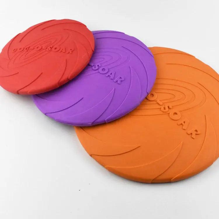 Three colorful frisbees (red, purple, orange) with 'SOAR' branding on a white background.