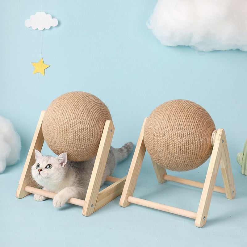 Two woven ball cat toys on wooden stands with a cat peeking out from one of them against a light blue background.