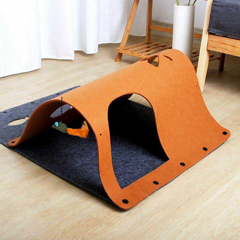 Orange pet playpen on a blue mat in a room with furniture and decor.