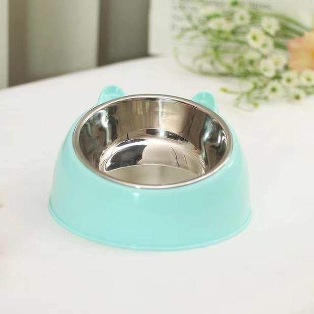Mint green pet bowl with a reflective silver interior on a white surface.