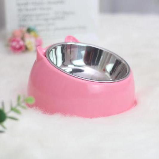 Pink pet bowl with a metal interior on a white surface.